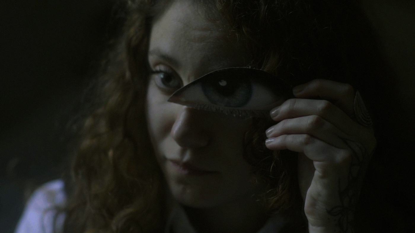 A woman with curly hair adjusts her glasses (1/1)