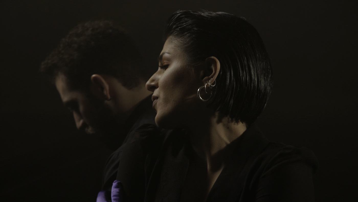A woman sings with her eyes closed in low light (4/9)