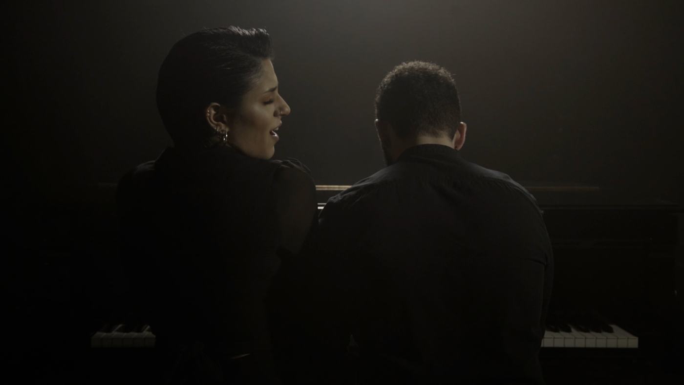 A woman sings with her eyes closed in low light (5/9)