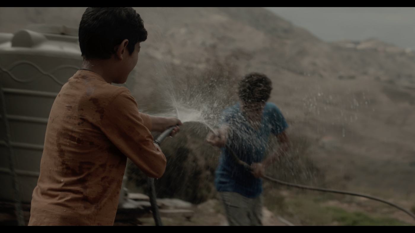A boy in a blue shirt looks off-frame in a dim truck cab (2/12)