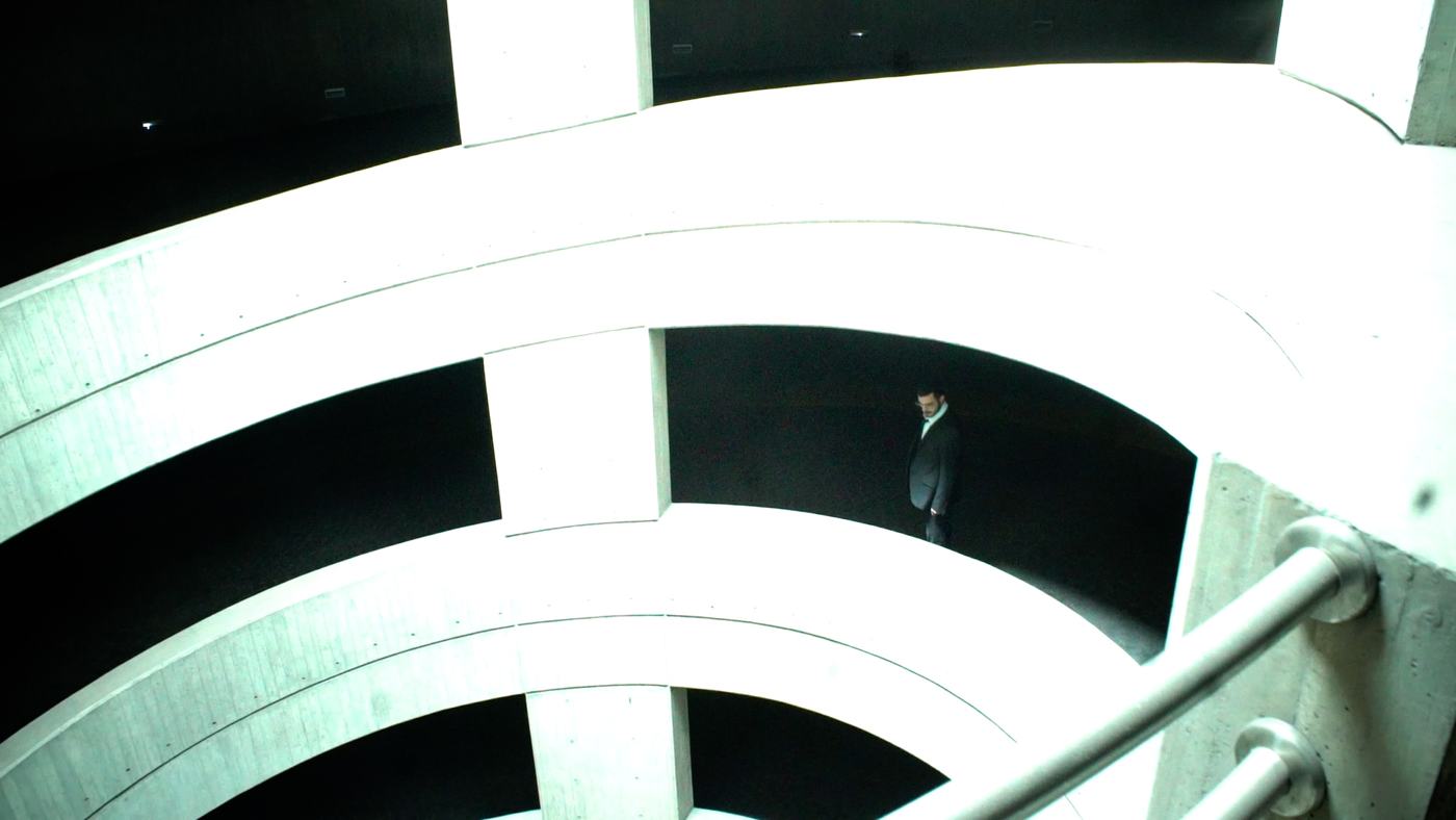A man in blue and green light lies back, eyes open (8/15)