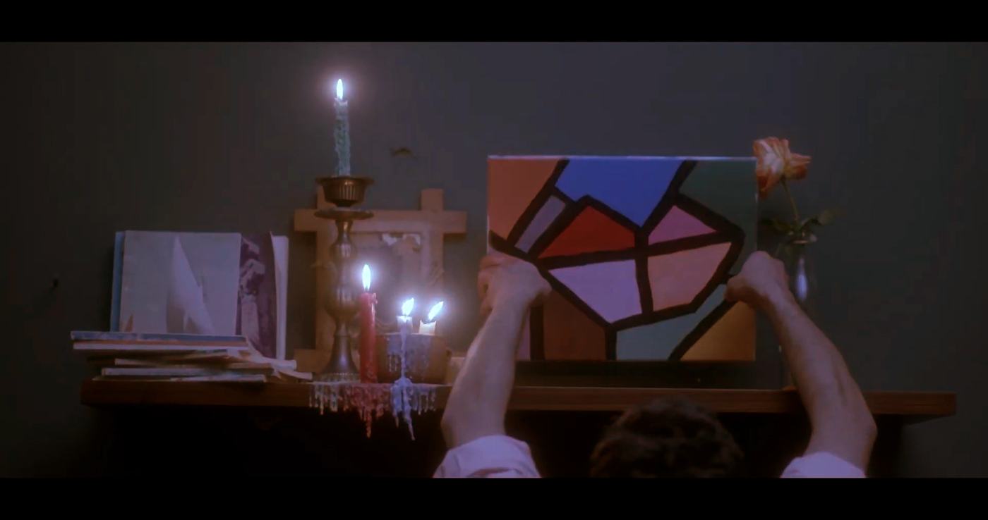 Candles and a stained-glass shape on a shelf, hands reaching in (1/2)